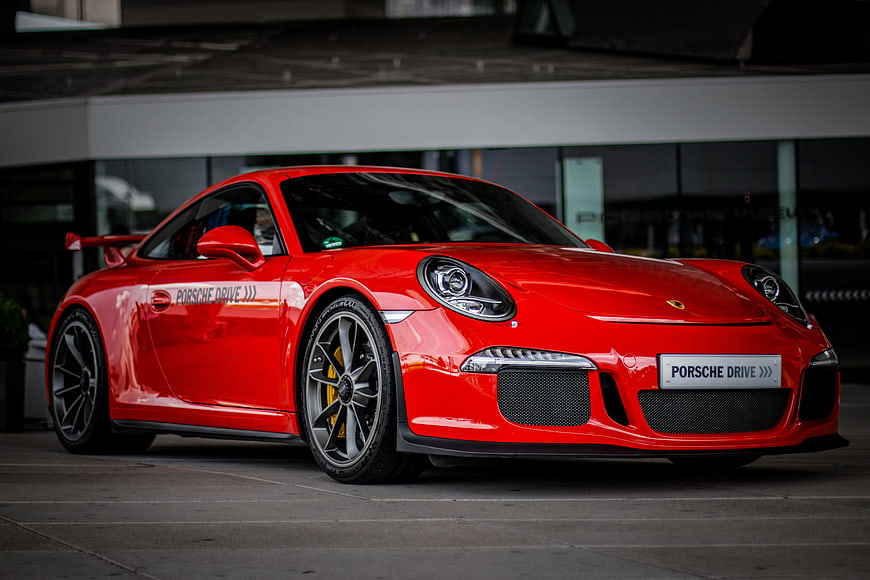 Red Porsche 911 GT3 991.1 parked in front of modern building