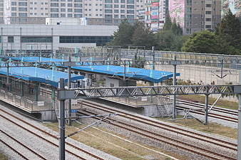Elevated Train Station Platform With Blue Canopies And Multiple Tracks