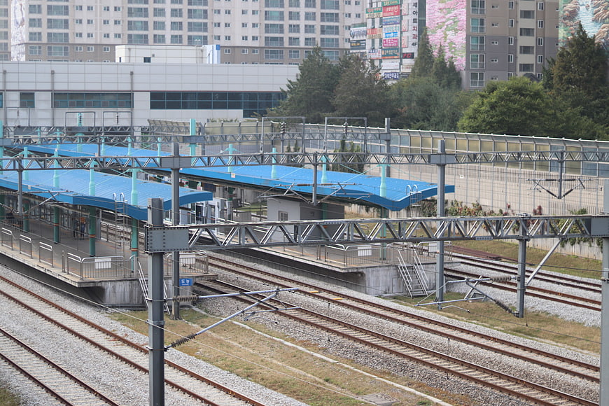Elevated Train Station Platform With Blue Canopies And Multiple Tracks