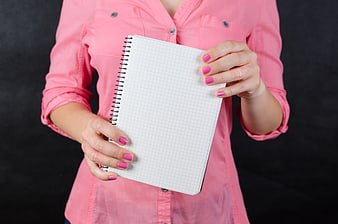 Woman in Pink Shirt Holding Blank Grid Notebook