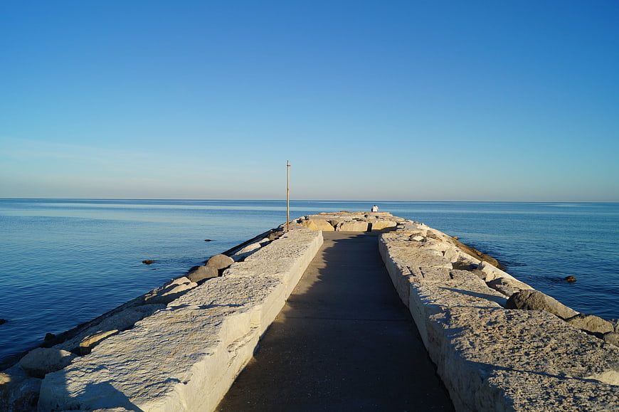Concrete Breakwater Pier Extending into Calm Blue Sea