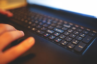 Close-up of hands typing on a laptop keyboard