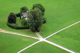 Aerial view of rural house at crossroads in green field