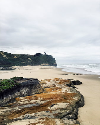 Scenic Rocky Beach with Cliffs and Overcast Sky