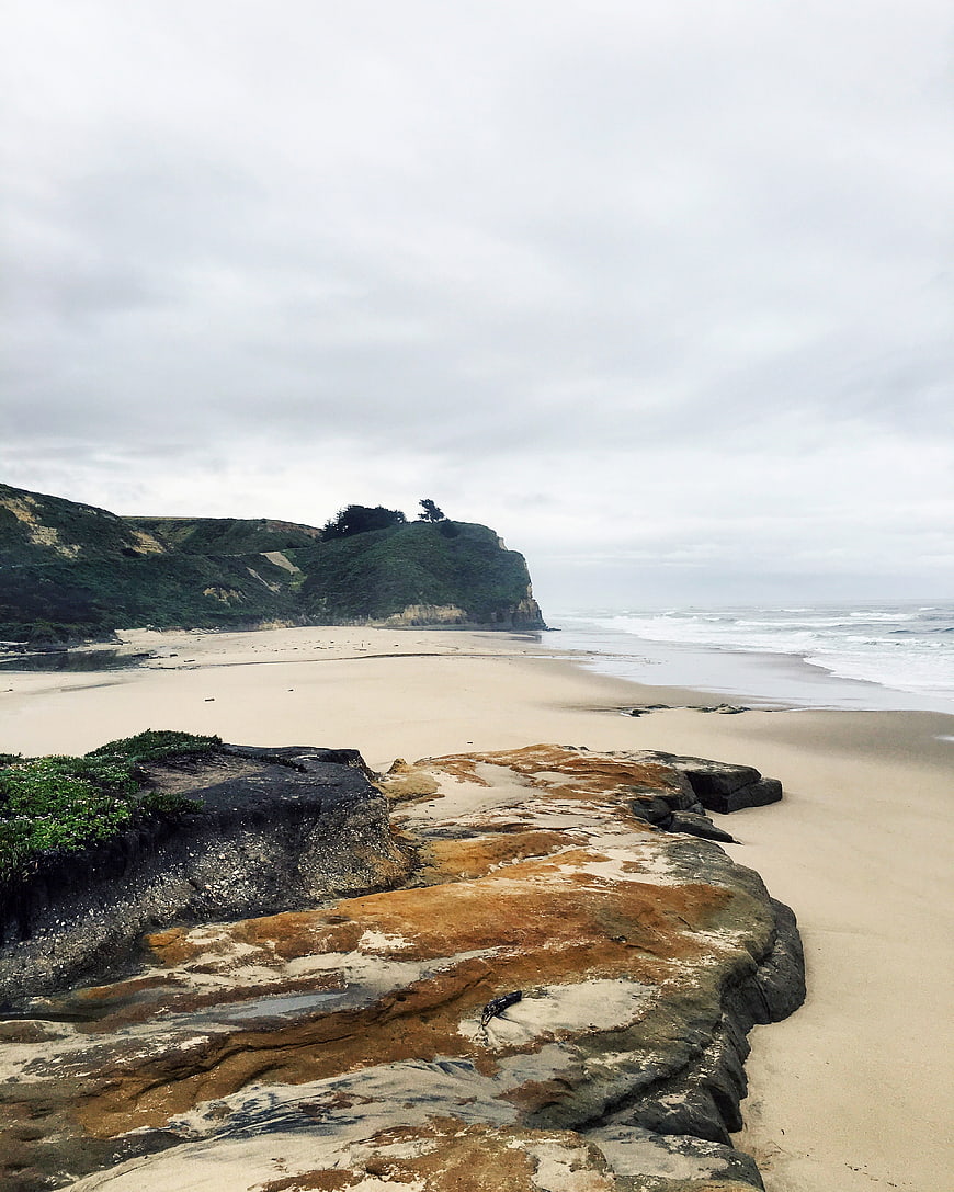 Scenic Rocky Beach with Cliffs and Overcast Sky