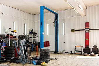 Interior of a professional automotive repair garage with blue car lift