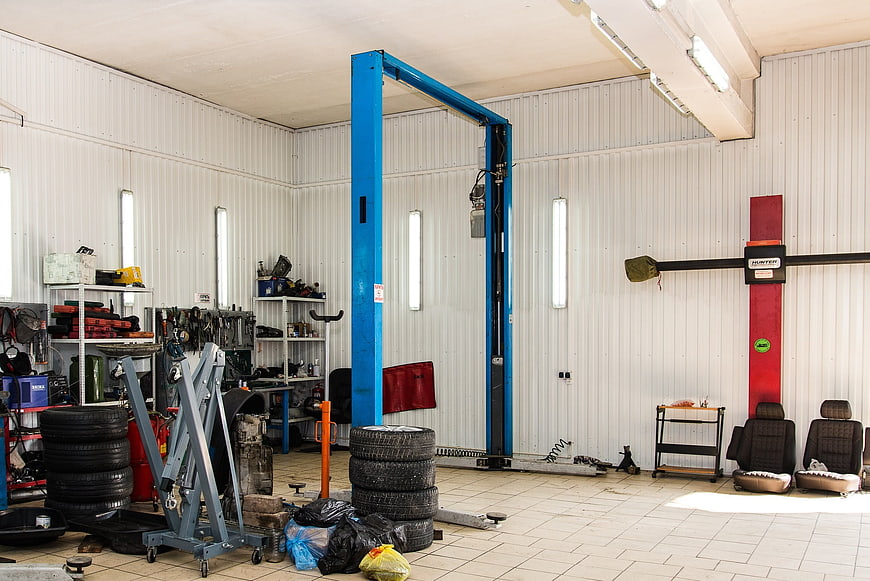 Interior of a professional automotive repair garage with blue car lift