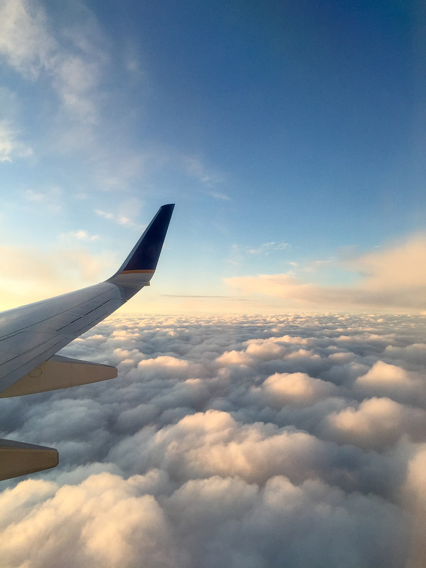 Airplane Wing View Above Clouds at Sunset