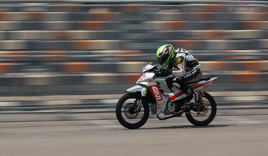 Motorcycle racer leaning into a turn on a race track