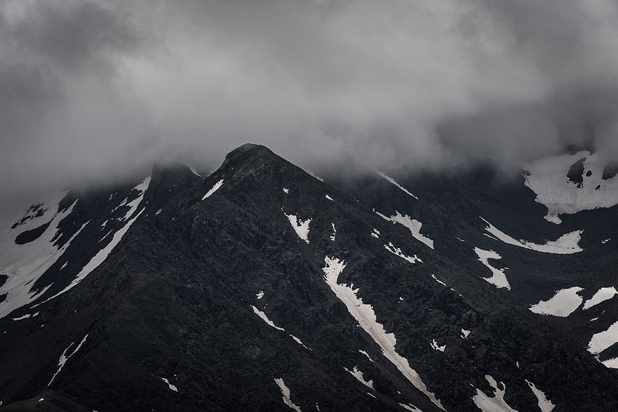 Dramatic black and white mountain peak shrouded in clouds
