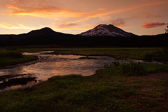 Sunset over Snow-Capped Mountain with River Reflection