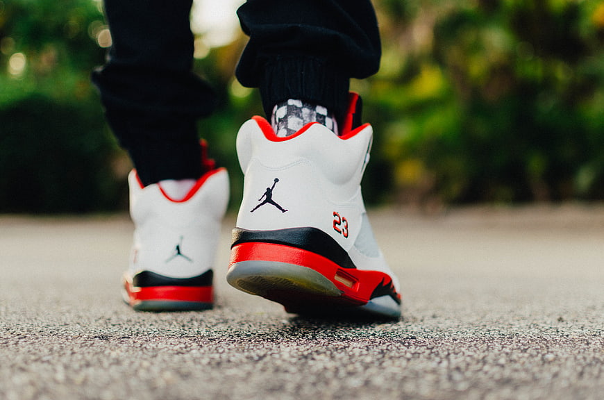 Rear View of White and Red Jordan 5 Sneakers Walking