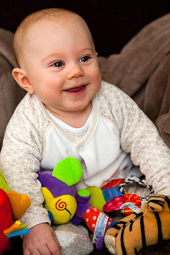 Cheerful Baby Smiling With Colorful Plush Toys