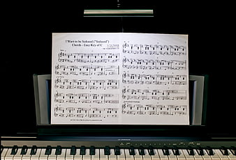 Piano Sheet Music on Stand in Dark Room