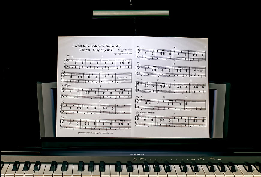 Piano Sheet Music on Stand in Dark Room