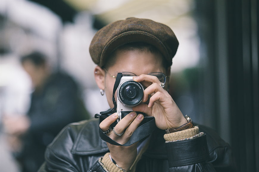 Woman photographer with vintage camera and flat cap