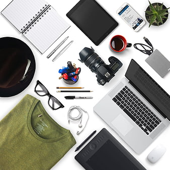 Flat lay of creative workspace with laptop, camera, and accessories
