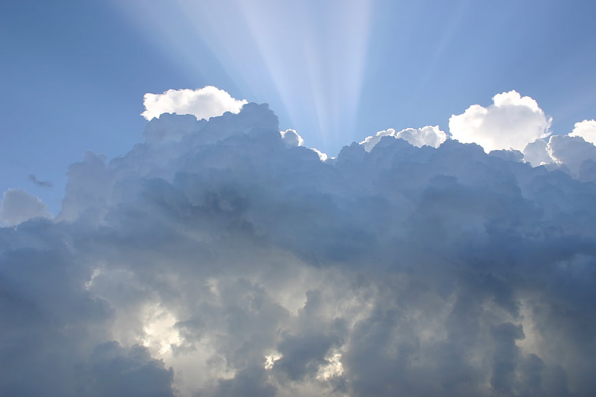 Dramatic Sun Rays Breaking Through Dark Cumulonimbus Clouds