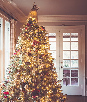 Decorated Christmas tree with angel topper in home interior