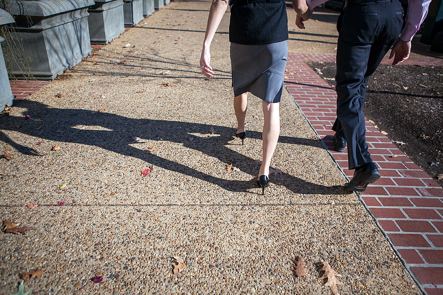 Business Couple Walking Away on City Sidewalk