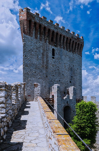 Medieval stone castle tower with blue sky and clouds