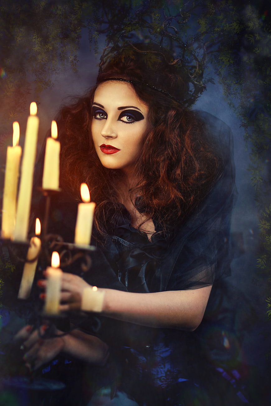 Gothic woman with dramatic makeup holding candelabra