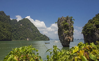 Tropical limestone karst island in emerald waters with lush greenery