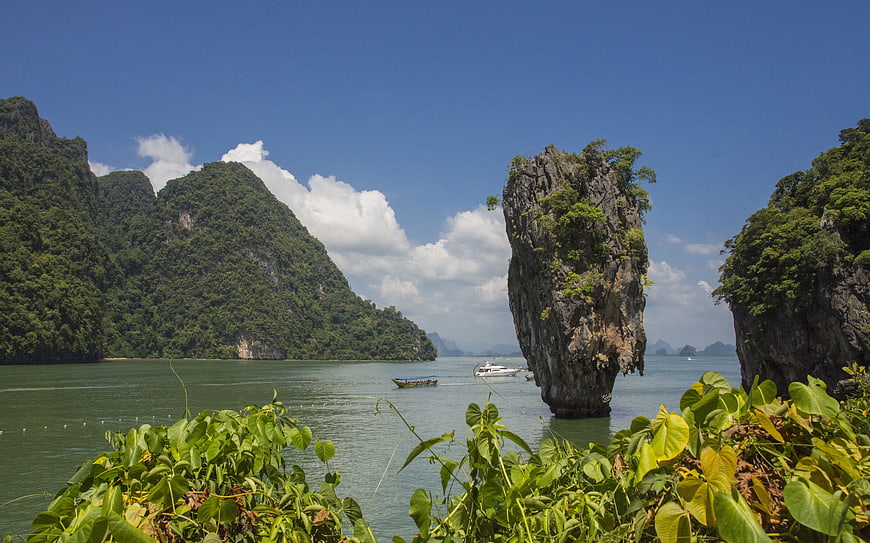 Tropical limestone karst island in emerald waters with lush greenery