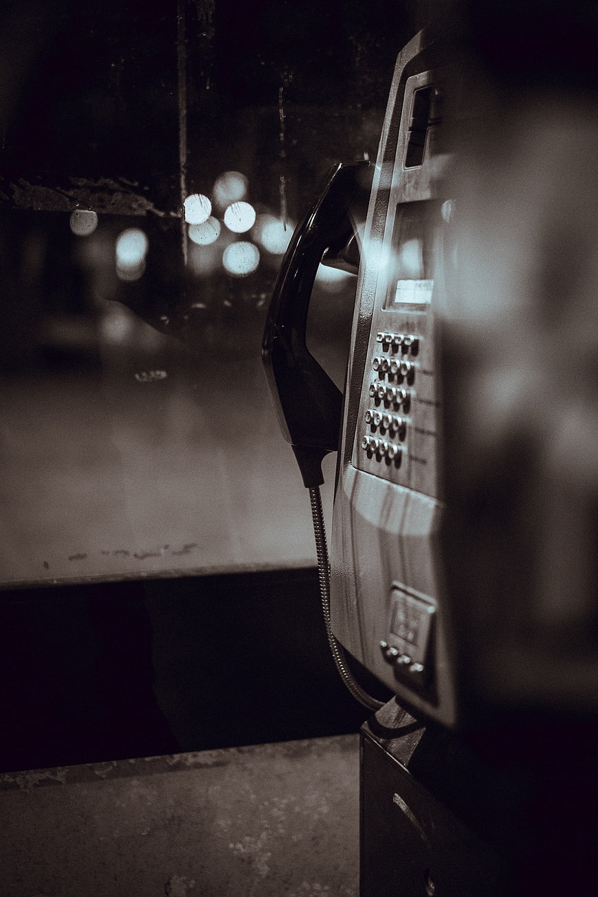 Vintage payphone in dark moody night setting