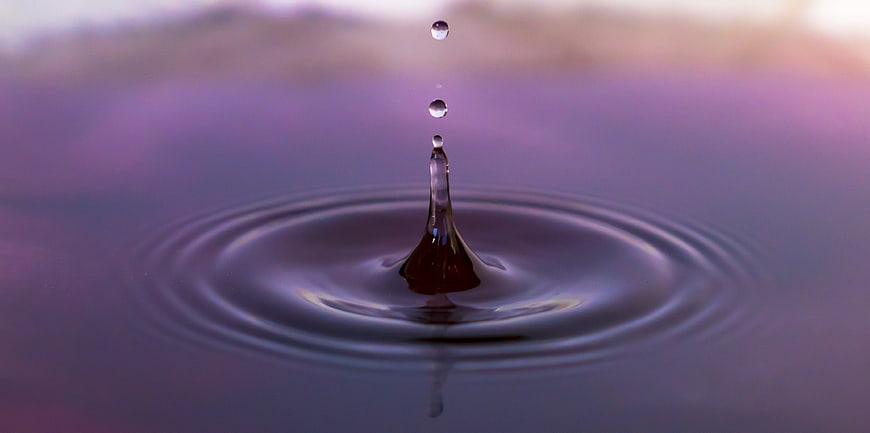 Macro Water Droplet Splash With Ripples And Purple Background