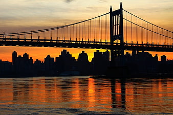 Manhattan Bridge Silhouette Against Vibrant Orange Sunset Skyline