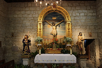 Catholic altar with crucifixion statues and golden frame
