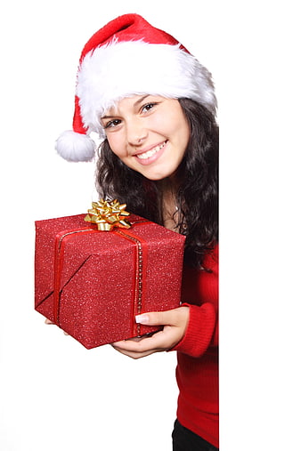 Smiling young woman in Santa hat holding red Christmas gift box
