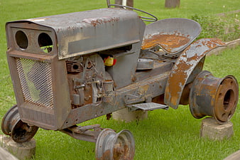 Rusty vintage garden tractor on wooden blocks