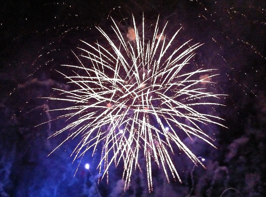 Bright white fireworks exploding in the night sky