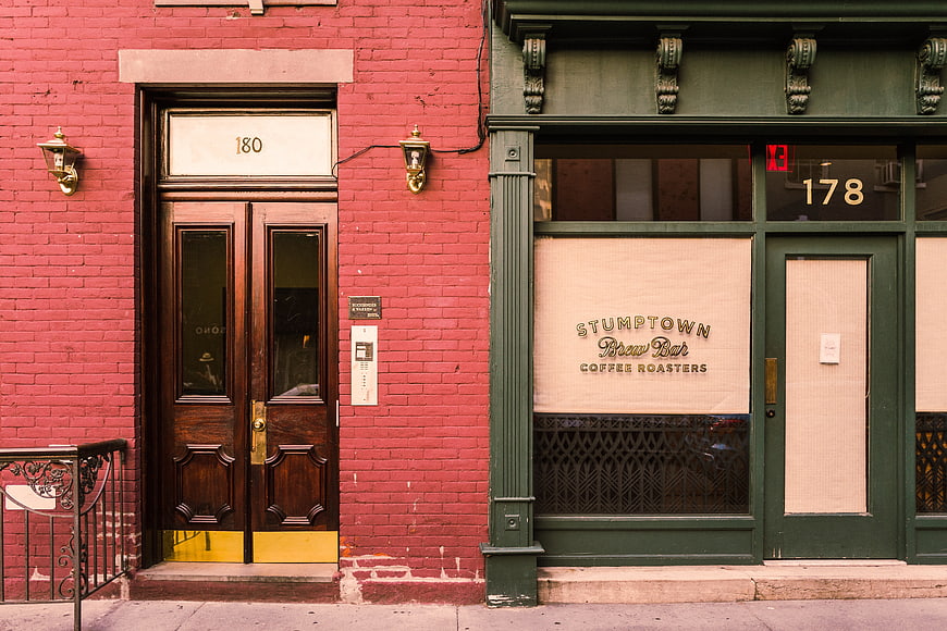 Red brick building and green Stumptown coffee shop storefront