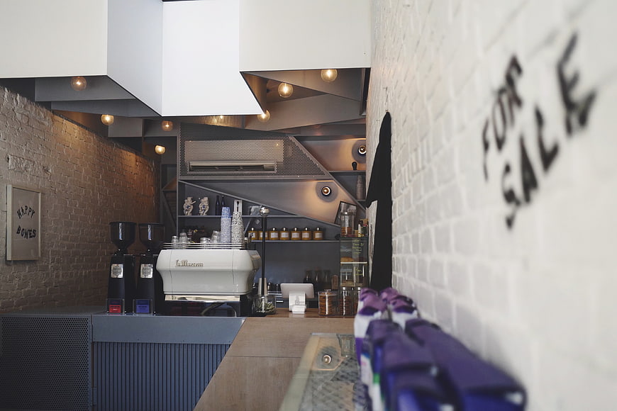 Modern Coffee Shop Interior with Espresso Machine and For Sale Sign