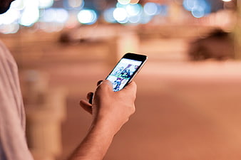 Man using smartphone at night with bokeh background