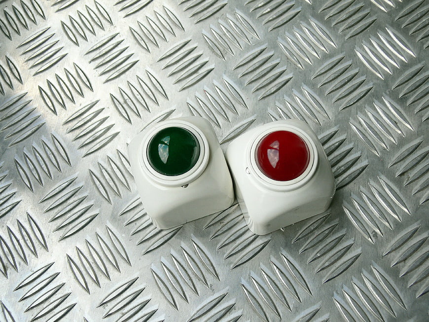 Red and Green Industrial Push Buttons on Metal Plate