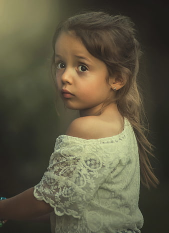 Portrait of a young girl with a worried expression looking back