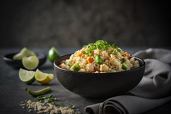 Bowl of cauliflower rice with vegetables and lime garnish