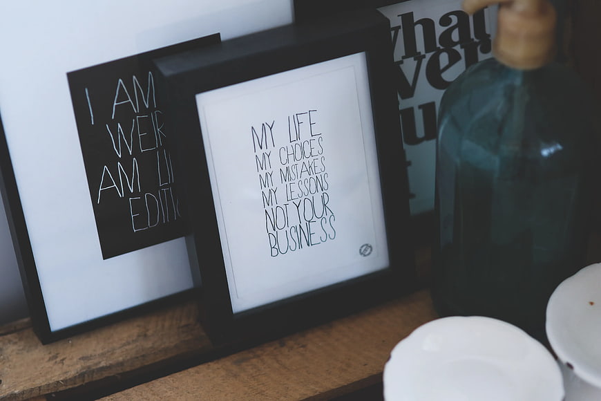 Framed motivational quotes on rustic wooden shelf