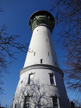 Low angle view of historic white water tower against blue sky