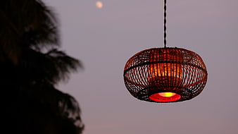 Glowing Woven Lantern Hanging Against Twilight Sky