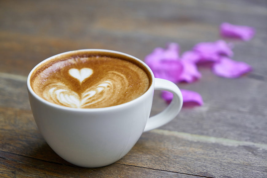 White Coffee Cup with Heart Latte Art and Purple Petals