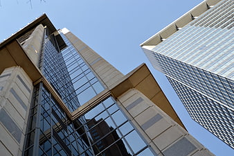 Low angle view of modern glass skyscrapers against clear blue sky