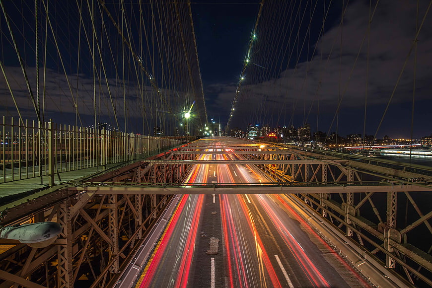 Long exposure night traffic on suspension bridge with light trails