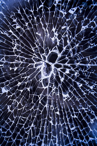 Close-up of shattered blue glass with radial cracks