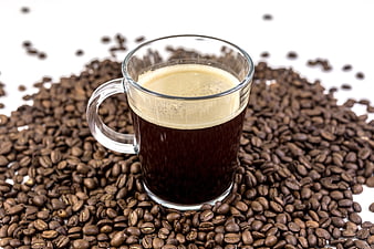 Glass Cup of Black Coffee on Roasted Coffee Beans