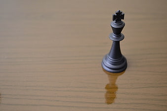 Black Chess King Piece on Wooden Surface